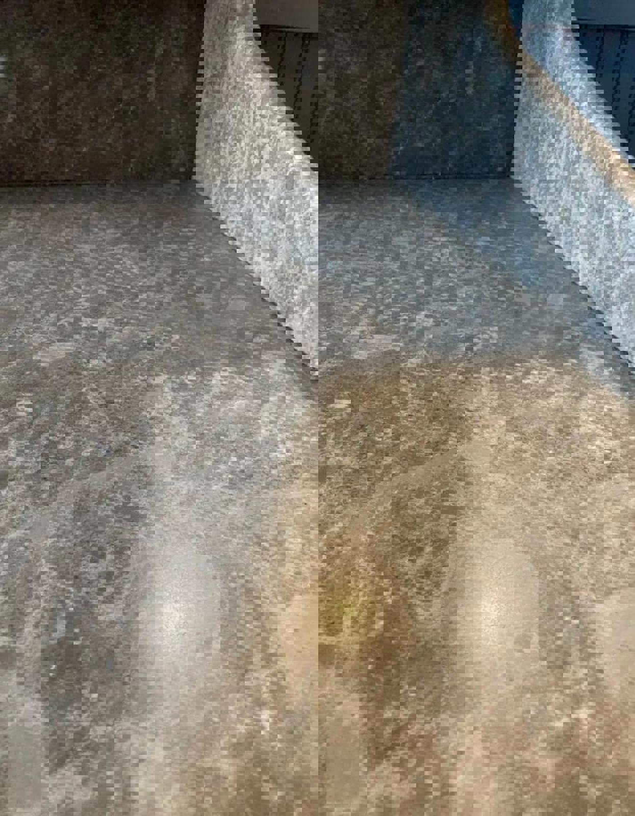 A close-up of a light gray marble countertop with a mottled, textured surface. The surface has a subtle sheen and is made of marble.