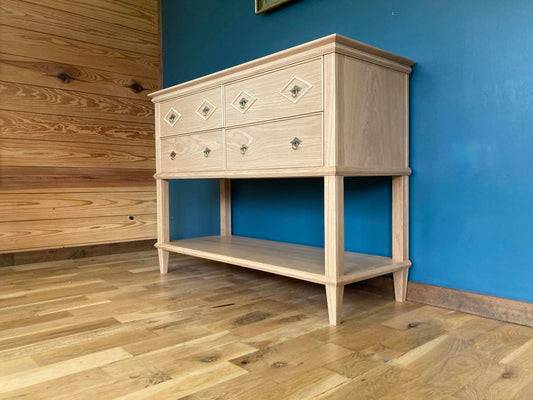 Wooden sideboard against a blue wall with wooden flooring