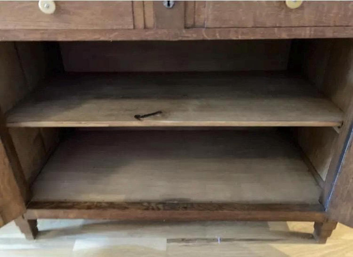 The inside of a wooden cabinet with two shelves. The shelves are empty and the cabinet is made of walnut