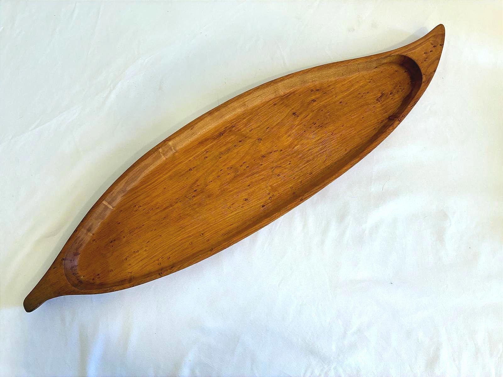 Vintage long Stanwood wooden tray with canoe shape, mid century carved wood serving tray with warm brown finish on white background.
