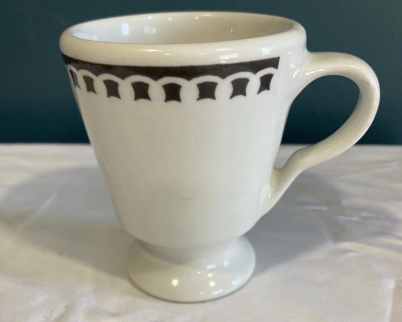 White mug with black decorative pattern on a white surface