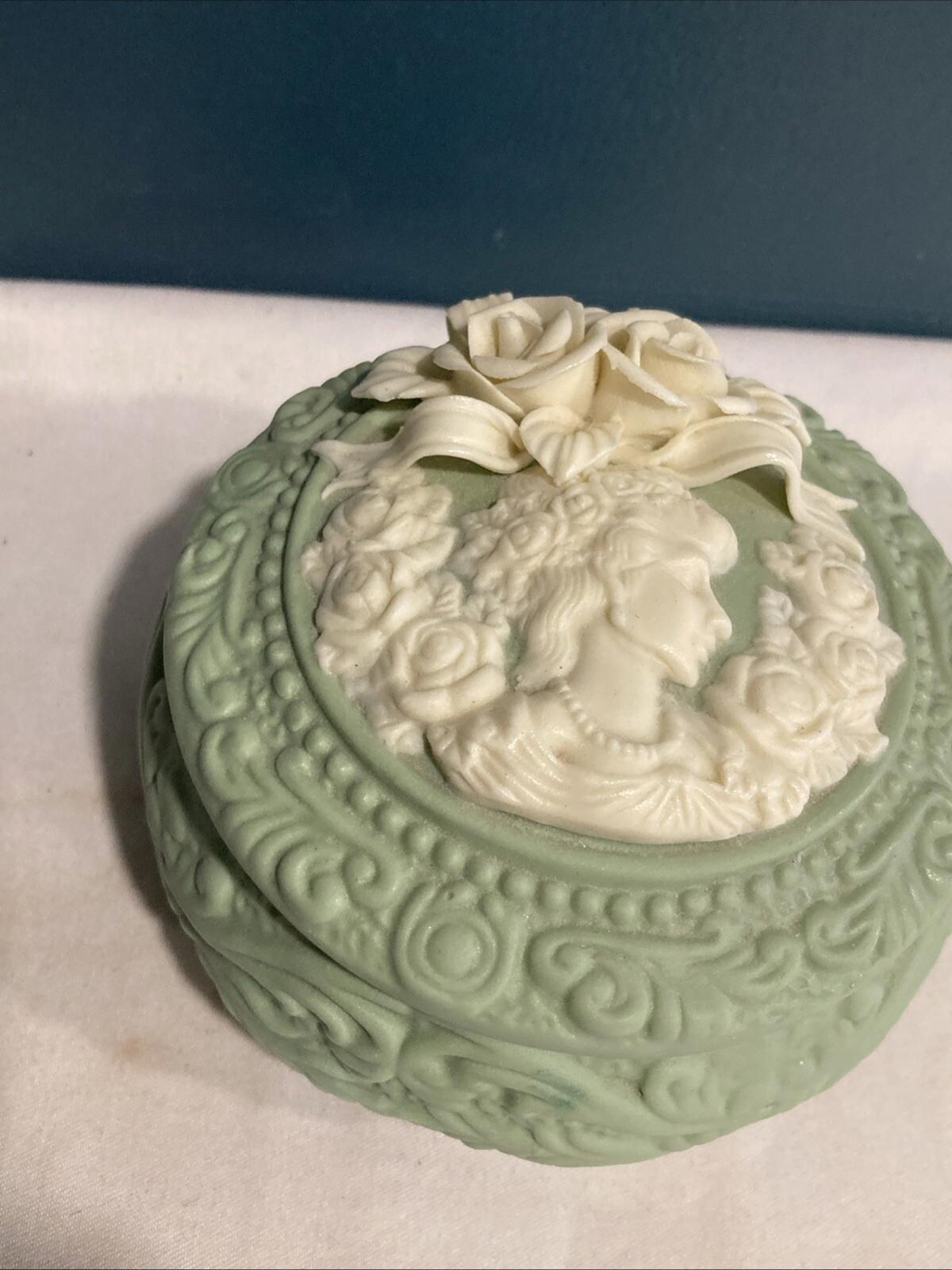 Decorative green box with a floral design on a marble surface