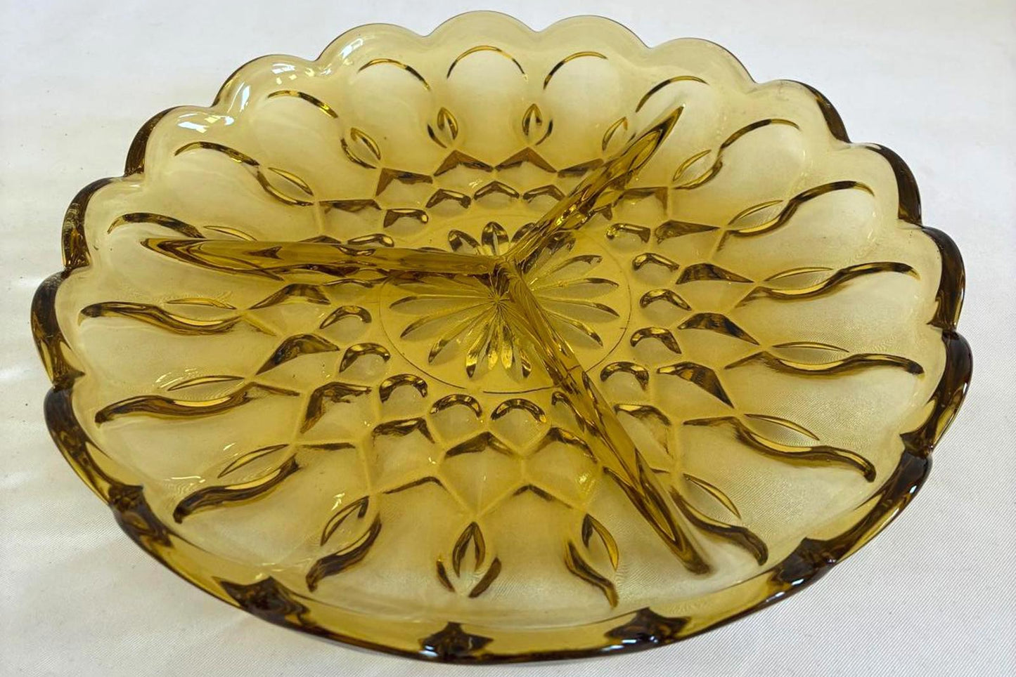 Yellow glass bowl with decorative pattern on a white background
