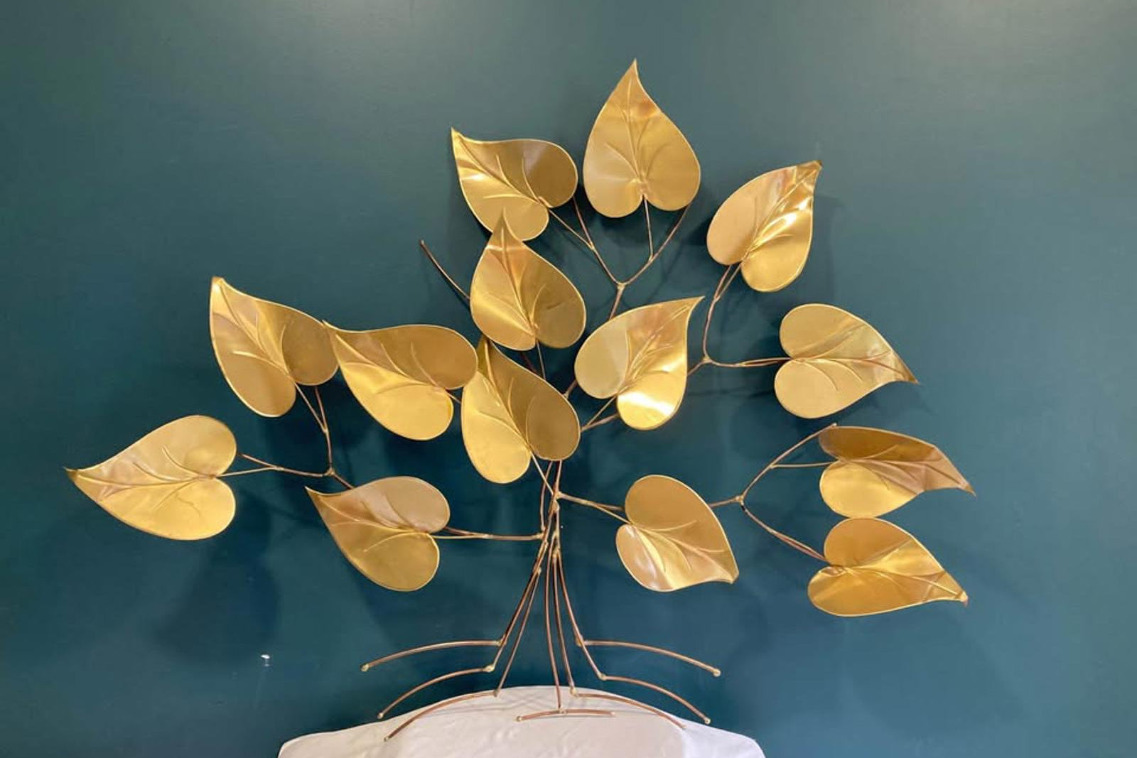 Gold leaf decorative piece against a teal wall