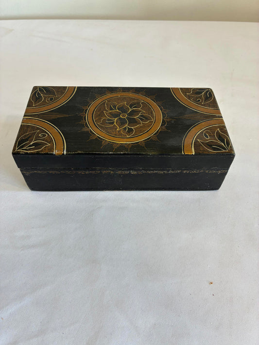 Decorative wooden box with gold patterns on a white background