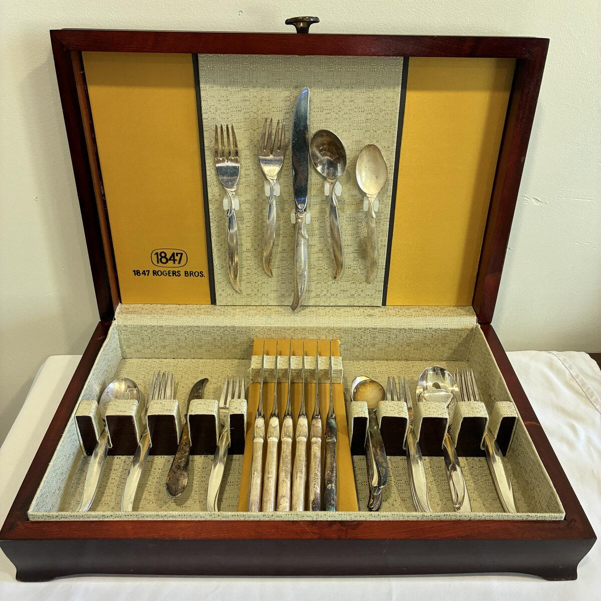 Set of silverware in a wooden case with a yellow interior