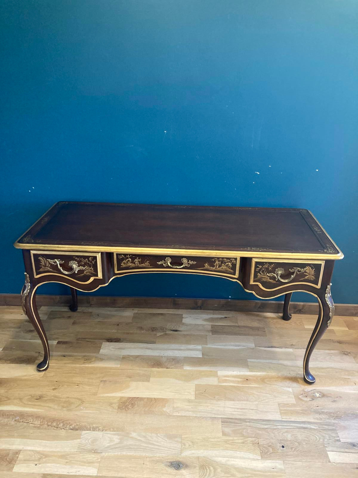 Decorative table with intricate designs against a blue and wooden wall.