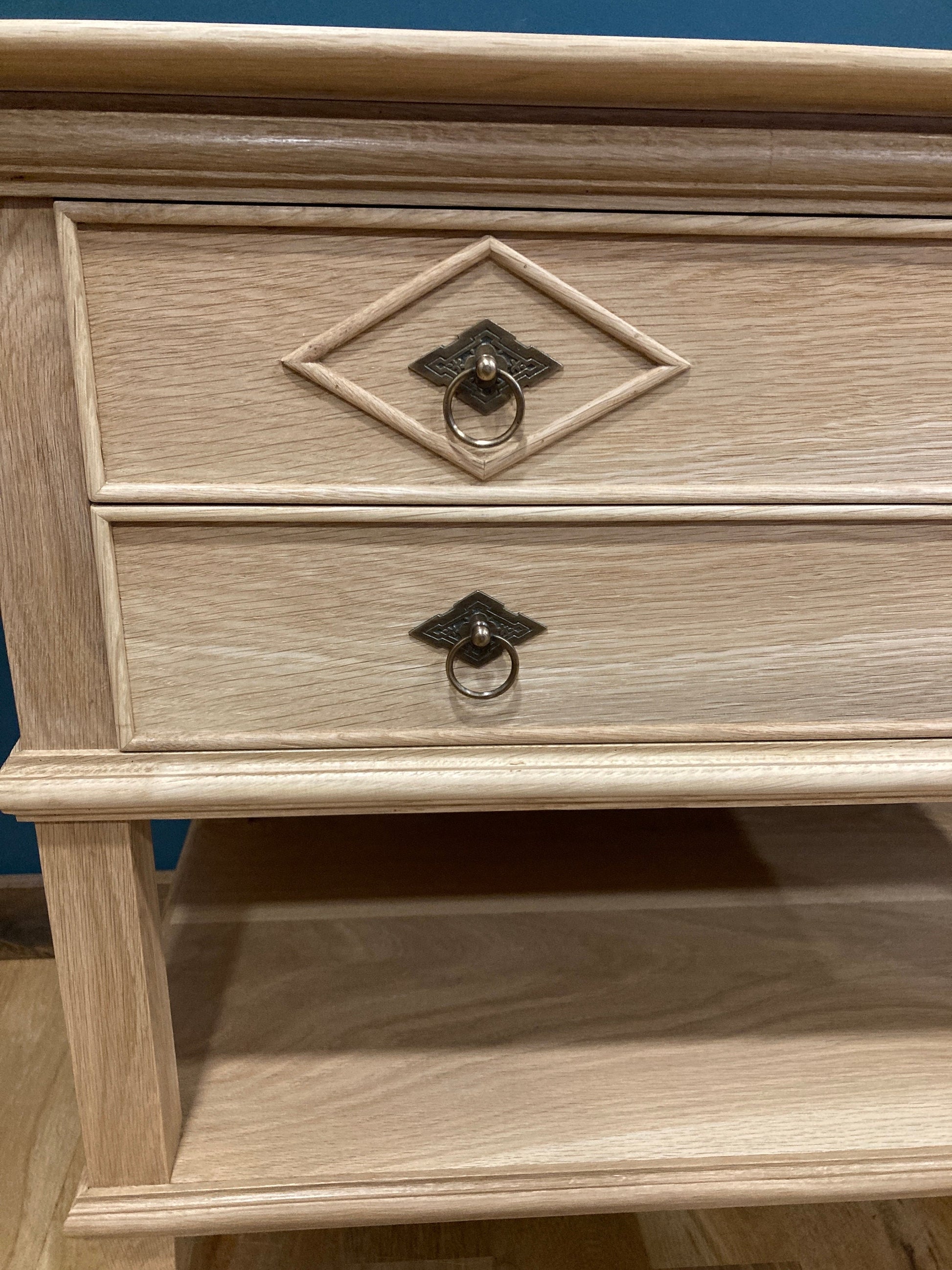 Close up view of two drawers and lower shelf on a solid wood nightstand.  