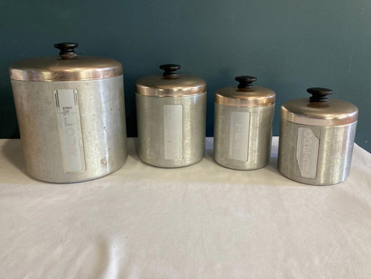 Set of four vintage aluminum Maid of Honor canisters with copper-tone lids labeled flour, sugar, coffee, and grease.