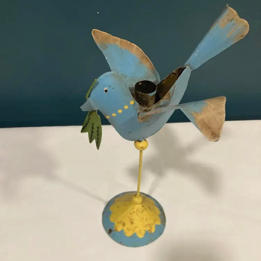 Decorative metal bird figurine with blue body and yellow feet on a white surface.