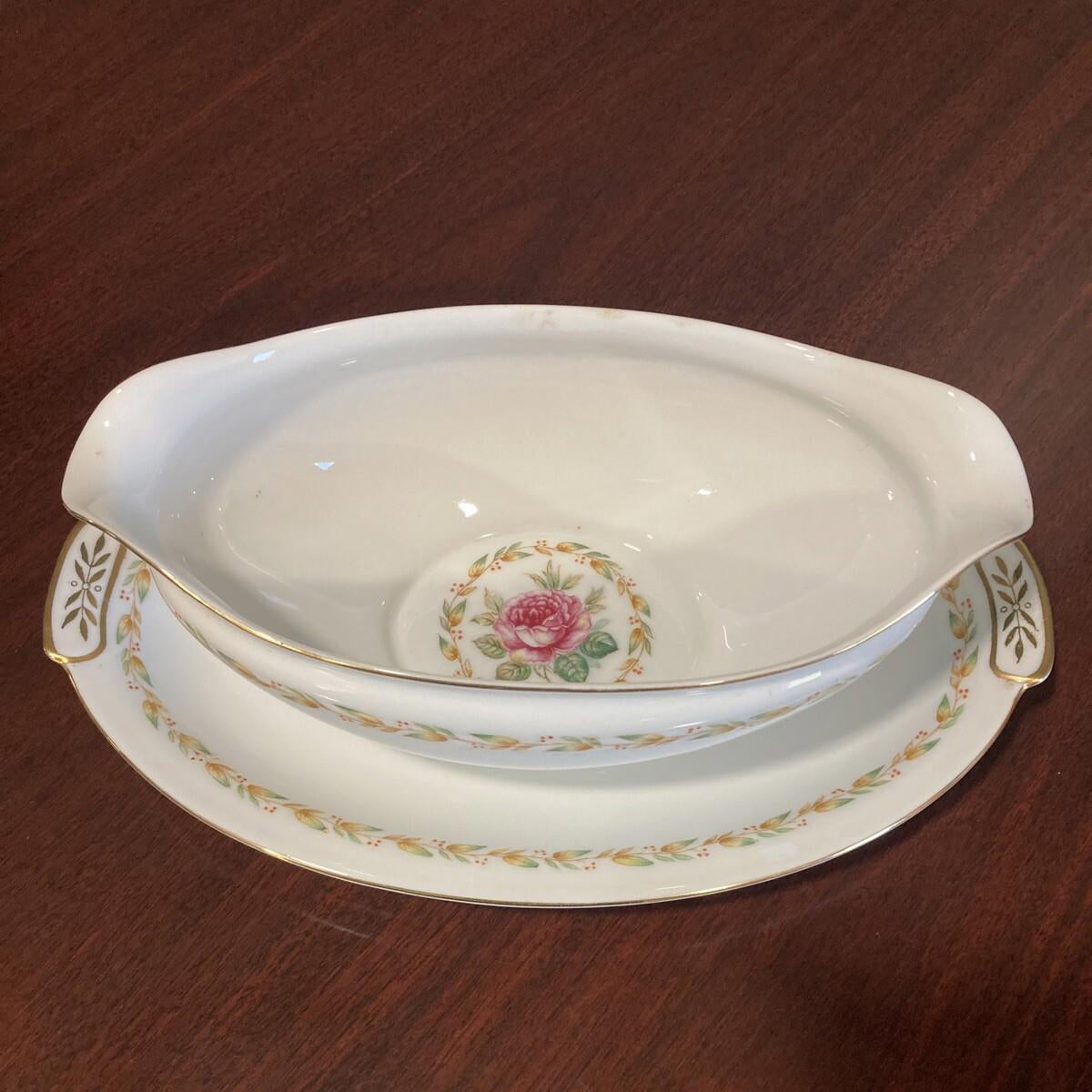 Decorative ceramic gravy dish with floral design on a wooden surface