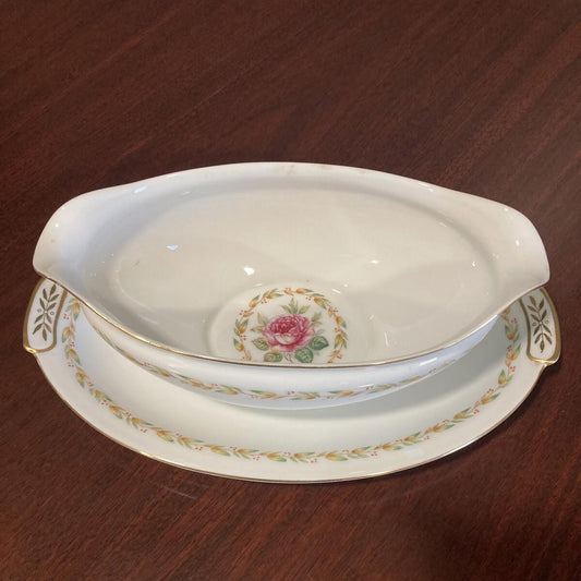 Decorative ceramic gravy dish with floral design on a wooden surface