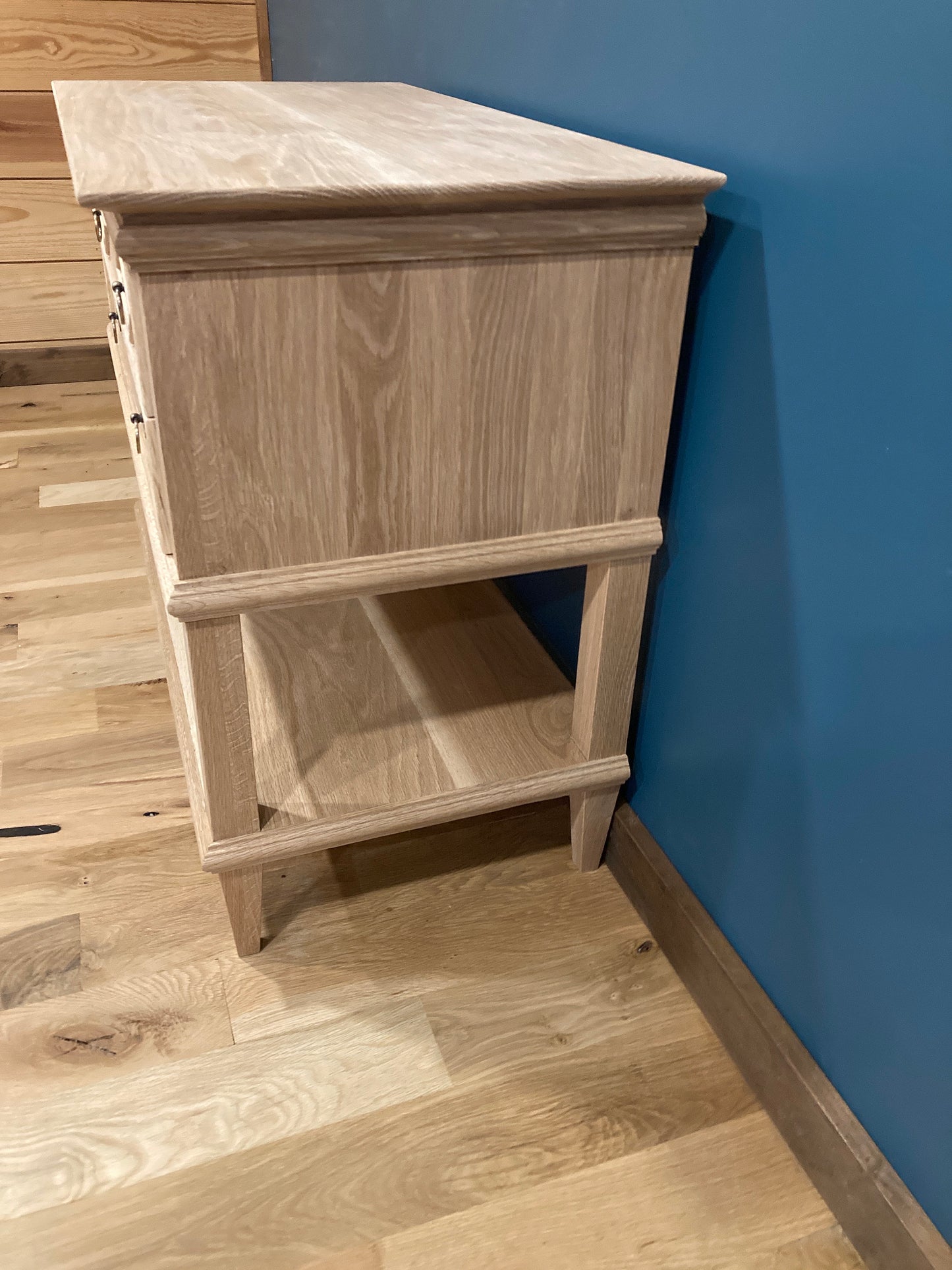 Side view of a solid wood nightstand with lower shelf. 