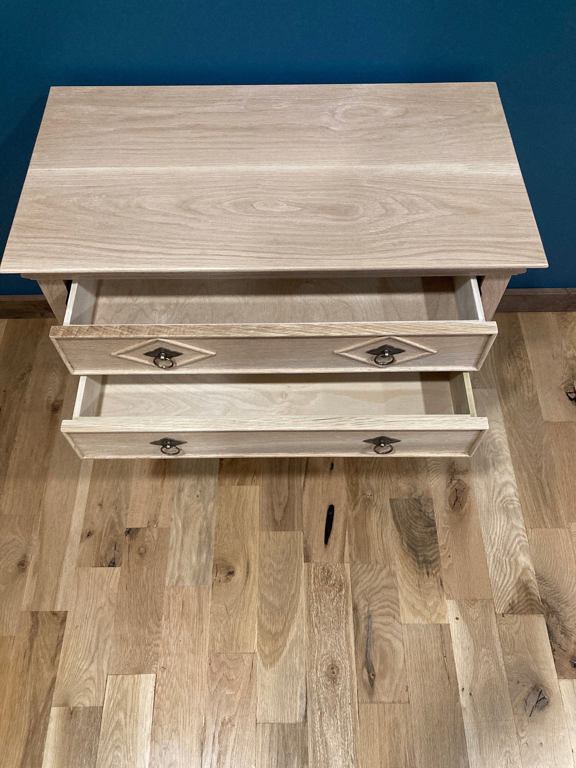 View of the top of a solid wood nightstand with the two drawers open to see inside.