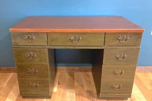 Wooden desk with drawers against a blue wall