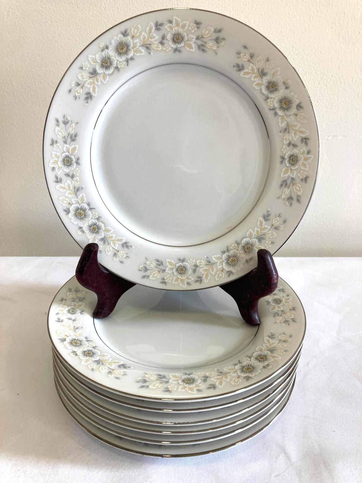 Set of seven floral-patterned ceramic plates on a white surface with a neutral background