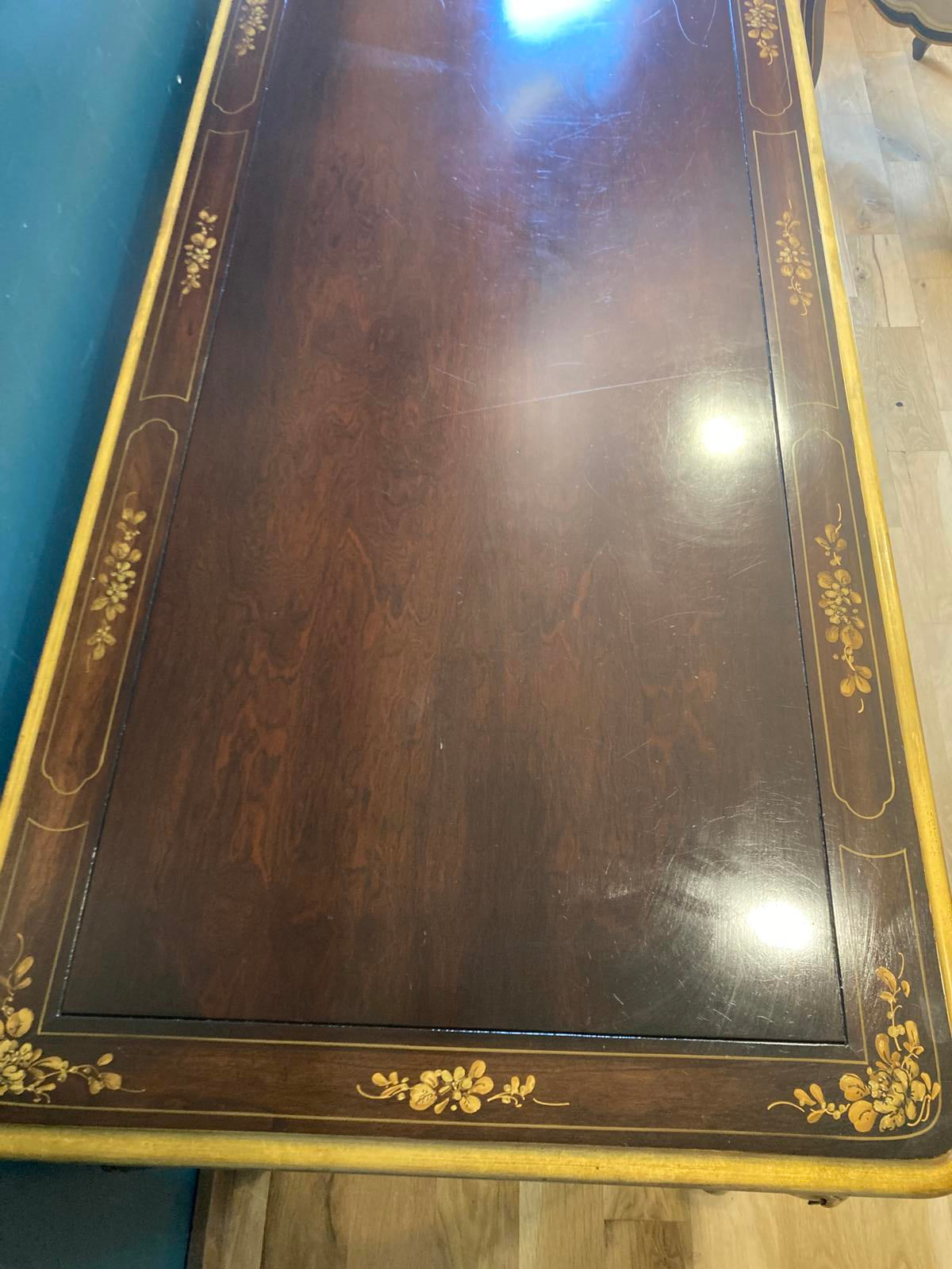 Wooden surface of a desk with decorative gold flowers and edging