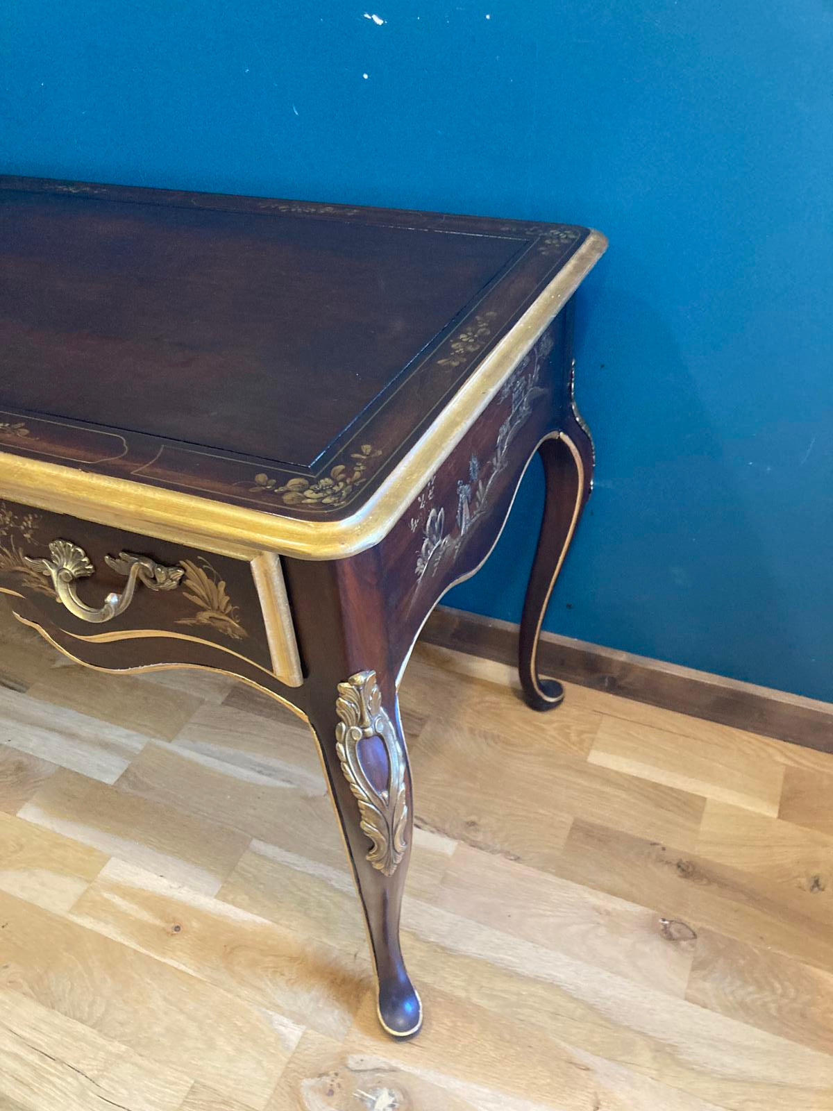 Decorative wooden desk with intricate carvings on a blue and wooden background