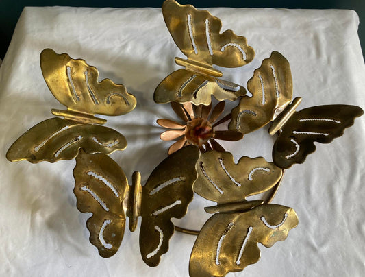Decorative brass butterfly wall art on a white background