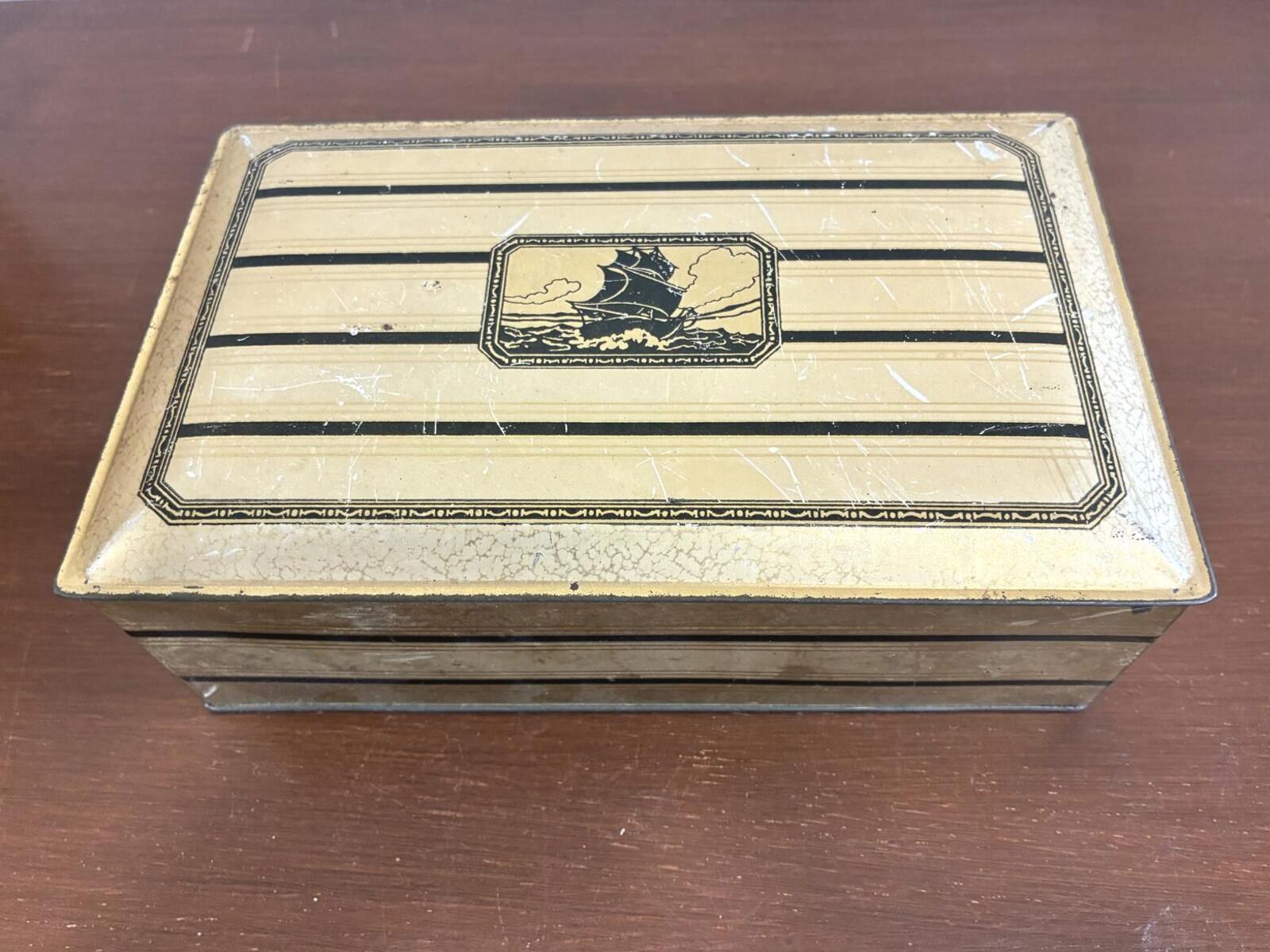 Vintage rectangular metal hinged storage box with nautical sailing ship motif and Art Deco striped design on lid.