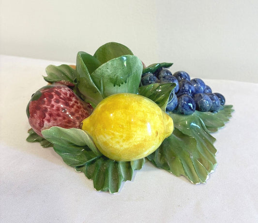Decorative fruit candle holder by Capodimonte Italy, with strawberry, lemon, and grapes on a white background