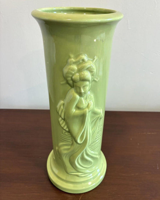 Vintage green ceramic vase featuring a raised relief figure of an Asian woman in flowing robes on a tall cylindrical vase with glossy chartreuse glaze.