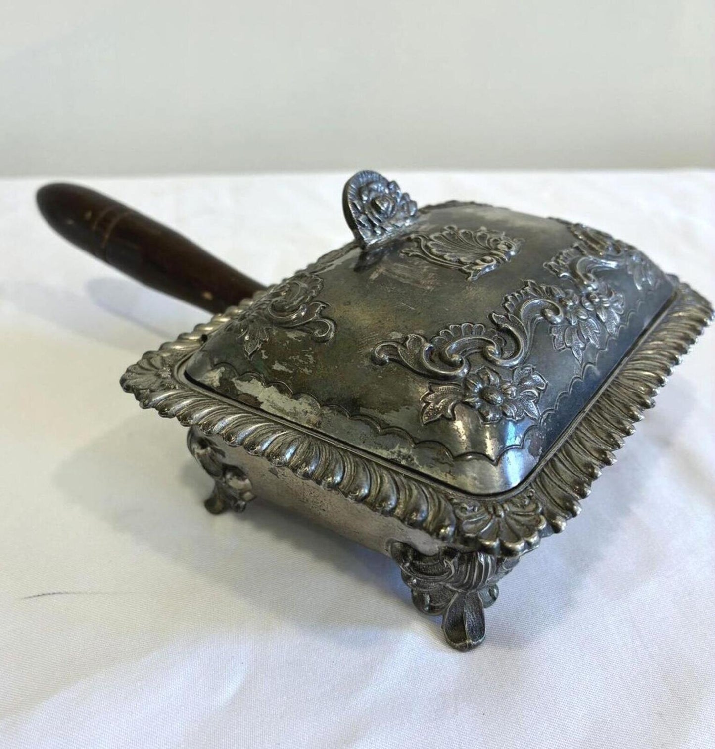 Decorative silver silent butler with a wooden handle on a white background